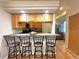 Kitchen bar with wood cabinets, granite countertops, and four stools is perfect for casual dining at 4493 Dunkirk Way, Denver, CO 80249