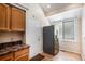 Kitchen featuring stainless steel refrigerator, wood cabinets, a window with natural light and an adjacent door at 4493 Dunkirk Way, Denver, CO 80249