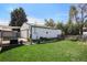 Spacious backyard with a lush lawn, a detached garage and seating area at 7891 Poplar St, Commerce City, CO 80022