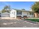Home exterior featuring driveway leading to detached garage, well-kept lawn and front porch at 7891 Poplar St, Commerce City, CO 80022