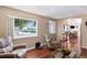 Inviting living room featuring hardwood floors, large window, and open view to kitchen at 7891 Poplar St, Commerce City, CO 80022
