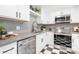 Modern kitchen featuring white cabinets, stainless appliances, and checkered flooring at 3080 S Eudora St, Denver, CO 80222