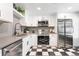 Updated kitchen with stainless steel appliances and black and white checkered floors at 3080 S Eudora St, Denver, CO 80222