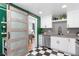 Kitchen featuring white cabinetry and a unique sliding door at 3080 S Eudora St, Denver, CO 80222