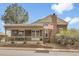 Charming brick home featuring a covered front porch and an American flag at 7291 E Bentley Cir, Centennial, CO 80122