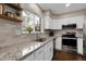Bright kitchen with granite counters, stainless appliances, white cabinets, and a window that lets in natural light at 7291 E Bentley Cir, Centennial, CO 80122