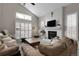 Bright living room features a white brick fireplace, plush furniture, and large windows with plantation shutters at 7291 E Bentley Cir, Centennial, CO 80122
