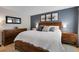 Spacious main bedroom features a king bed, wood furniture, neutral carpet, and a gray accent wall at 7291 E Bentley Cir, Centennial, CO 80122