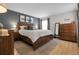 Spacious main bedroom features a king bed, wood furniture, neutral carpet, and a gray accent wall at 7291 E Bentley Cir, Centennial, CO 80122
