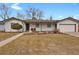 Charming single-story home featuring a well-maintained lawn, white siding and an attached two-car garage at 3175 Zinnia Ct, Golden, CO 80401