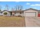 Charming single-story home featuring a well-maintained lawn, white siding and an attached two-car garage at 3175 Zinnia Ct, Golden, CO 80401
