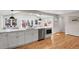 Modern kitchen featuring white cabinets, stainless steel appliances, an island with seating, and hardwood floors at 3175 Zinnia Ct, Golden, CO 80401