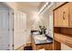 Bathroom featuring double sinks, a large mirror, and wooden cabinets at 14700 E 104Th Ave # 2802, Commerce City, CO 80022