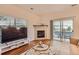 Comfortable living room with a fireplace, a sliding glass door to balcony, and a TV at 14700 E 104Th Ave # 2802, Commerce City, CO 80022