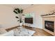 Bright living room with a cozy fireplace, large plant, and stylish decor at 14700 E 104Th Ave # 2802, Commerce City, CO 80022