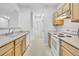 Cozy kitchen with wooden cabinets, white appliances, and a double basin sink offers a functional cooking space at 5255 Memphis St # 317, Denver, CO 80239
