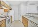 Functional kitchen featuring white appliances and classic wood cabinetry at 5255 Memphis St # 317, Denver, CO 80239