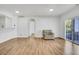 Bright living room with beautiful floors, a leather chair, and access to a balcony at 5255 Memphis St # 317, Denver, CO 80239
