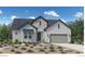 Charming farmhouse with stone accents, neutral gray siding, and a well-manicured front yard at 851 Coal Bank Trl, Castle Rock, CO 80104