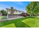 Spacious backyard featuring a well-maintained lawn, flower beds, and a wooden deck at 5870 Quail St, Arvada, CO 80004