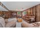 Basement living room featuring wood paneling, comfortable couches, and a media center for entertainment at 5870 Quail St, Arvada, CO 80004