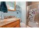 Bright bathroom with granite countertop, wooden vanity, and glass enclosed shower, perfect for relaxation at 5870 Quail St, Arvada, CO 80004