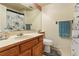 Well-maintained bathroom featuring a vanity, mirror, toilet, and a shower with a patterned curtain at 5870 Quail St, Arvada, CO 80004
