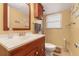 Bathroom with a wooden vanity, large mirror, and a window allowing natural light to brighten the room at 5870 Quail St, Arvada, CO 80004