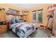 Cozy bedroom with a quilt bed, built-in storage, and multiple windows offering views of the yard at 5870 Quail St, Arvada, CO 80004