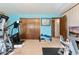 Home gym featuring exercise equipment, wood-paneled walls, and natural light, creating an active lifestyle at 5870 Quail St, Arvada, CO 80004