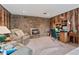 Inviting living room with a stone fireplace, wood paneling, and comfortable seating, ideal for relaxation at 5870 Quail St, Arvada, CO 80004