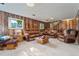 Bright living room featuring wood paneled walls, carpet, and comfortable seating, great for Gathering gatherings at 5870 Quail St, Arvada, CO 80004