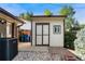 Tan backyard shed with double doors and adjacent rock landscaping at 5870 Quail St, Arvada, CO 80004