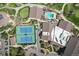 Aerial shot highlighting tennis courts, pool, golf putting green, and building rooftops at 13850 E Marina Dr # 304, Aurora, CO 80014