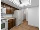 Compact kitchen features white appliances, wooden cabinets and access to the hall at 13850 E Marina Dr # 304, Aurora, CO 80014
