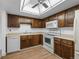 Functional kitchen offering wooden cabinets, essential appliances, and updated flooring at 13850 E Marina Dr # 304, Aurora, CO 80014