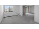 Bright living room with large window and sliding glass door, featuring neutral carpet and baseboard heating at 13850 E Marina Dr # 304, Aurora, CO 80014
