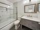 Modern bathroom featuring marble-style tile, a glass shower door, and a gray vanity with chrome finishes at 8536 S Upham Way, Littleton, CO 80128