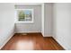 Empty bedroom features hardwood floors, a window letting in natural light, and white walls at 8536 S Upham Way, Littleton, CO 80128