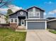 Charming two-story home features a gray exterior, attached garage, and well-maintained front yard at 8536 S Upham Way, Littleton, CO 80128