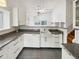 Bright kitchen features white cabinets, granite countertops, stainless steel appliances, and modern lighting at 8536 S Upham Way, Littleton, CO 80128