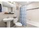 Bathroom with a pedestal sink, tile flooring, toilet, and a shower-tub combo with curtain at 6731 Pinery Villa Pl, Parker, CO 80134