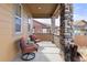 Relaxing front porch with comfortable seating, stone columns, and charming decor at 6731 Pinery Villa Pl, Parker, CO 80134