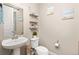 Charming powder room with a pedestal sink, decorative shelves, and coastal-themed artwork at 6731 Pinery Villa Pl, Parker, CO 80134