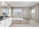 Serene bathroom with a soaking tub, glass-enclosed shower, and a double sink vanity at 6731 Pinery Villa Pl, Parker, CO 80134