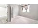 Well-lit bedroom with neutral walls, carpet, large window, and an ensuite bathroom with a tub/shower combination at 14343 E Dickinson Dr # E, Aurora, CO 80014