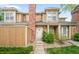 Charming townhouse showcasing the front door, complemented by green bushes and well-maintained landscaping at 14343 E Dickinson Dr # E, Aurora, CO 80014