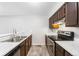 Galley kitchen features sleek appliances, wooden cabinets, light countertops, and durable floors at 14343 E Dickinson Dr # E, Aurora, CO 80014
