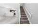 Open-concept living room with neutral decor, carpet flooring, and stairs leading to the upper level, adjacent to the kitchen at 14343 E Dickinson Dr # E, Aurora, CO 80014