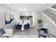 Living area featuring modern decor, stairs to the upper level, an open kitchen, and contemporary artwork at 14343 E Dickinson Dr # E, Aurora, CO 80014